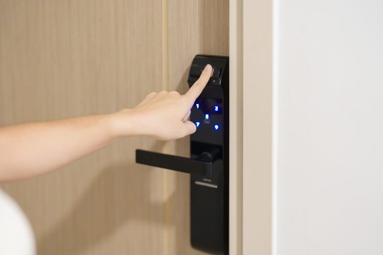 Hand using fingerprint scan for smart digital door lock while op